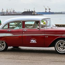Un coche clásico estadounidense pasa frente al submarino ruso de propulsión nuclear Kazán, parte del destacamento naval ruso que visita Cuba, cuando llega al puerto de La Habana. | Foto:ADALBERTO ROQUE/AFP