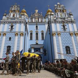 Los dolientes se arrodillan mientras los militares ucranianos llevan el ataúd del militar ucraniano, el fotógrafo Arsen Fedosenko, quien fue asesinado en la región de Kharkiv, en el Monasterio de las Cúpulas Doradas de San Miguel en Kiev, en medio de la invasión rusa en Ucrania. | Foto:Anatolii Stepanov / AFP