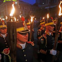 Soldados rumanos sostienen antorchas durante una marcha para conmemorar el Día de los Héroes, en el centro de Bucarest, Rumania. | Foto:Xinhua/Cristian Cristel