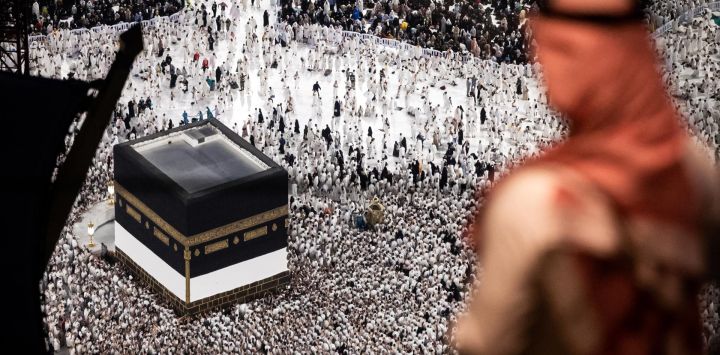 Un hombre se encuentra en un restaurante mientras los fieles musulmanes caminan alrededor de la Kaaba, el santuario más sagrado del Islam, en la Gran Mezquita de la ciudad santa de La Meca en Arabia Saudita, antes de la peregrinación anual Hajj.