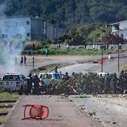 Los gendarmes franceses vigilan la situación en medio del humo de gases lacrimógenos mientras se producen enfrentamientos con manifestantes independentistas durante la retirada de un control de carretera en la avenida Paul-Emile Victor en Dumbea, en el territorio francés del Pacífico de Nueva Caledonia, el 24 de junio de 2024. Los enfrentamientos comenzaron incluso después de la independencia. Activistas vinculados a un grupo acusado de orquestar disturbios mortales el mes pasado en Nueva Caledonia han sido enviados a Francia continental para permanecer en prisión preventiva. En mayo estallaron disturbios, barricadas callejeras y saqueos en Nueva Caledonia por una reforma electoral que habría permitido a los residentes de larga duración participar en las elecciones locales. (Foto de Delphine MAYEUR / AFP) | Foto:AFP