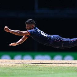 Nosthush Kenjige, de EE. UU., se zambulle para salvar una carrera durante el partido de críquet Super Eight masculino de la Copa Mundial Twenty20 2024 de la ICC entre EE. UU. e Inglaterra en el Kensington Oval en Bridgetown, Barbados, el 23 de junio de 2024. (Foto de Chandan Khanna / AFP) | Foto:AFP