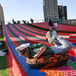 La gente se desliza por un tobogán en un parque en Ulán Bator, Mongolia, el 23 de junio de 2024. (Foto de HECTOR RETAMAL / AFP) | Foto:AFP