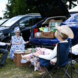 Los asistentes a las carreras hacen un picnic detrás del maletero de su automóvil en el estacionamiento antes de asistir al cuarto día de la reunión de carreras de caballos Royal Ascot, en Ascot, al oeste de Londres, el 21 de junio de 2024. (Foto de Ben Stansall / AFP) | Foto:AFP