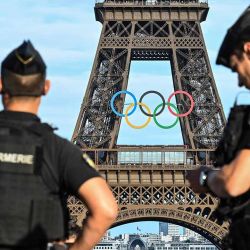 Oficiales de la gendarmería francesa patrullan frente al Parvis des Droits de l'Homme, frente a la Torre Eiffel adornada con anillos olímpicos para los próximos Juegos Olímpicos de París 2024, en París, el 19 de junio de 2024. (Foto de Stefano RELLANDINI / AFP) | Foto:AFP