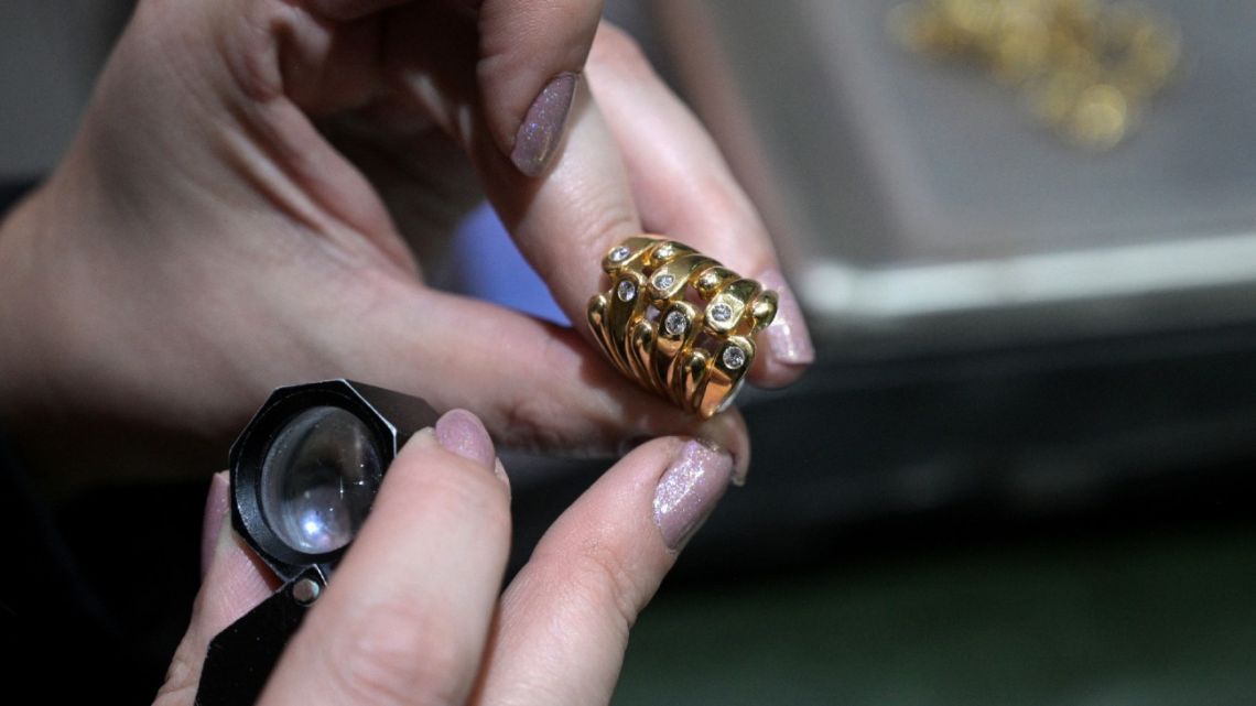 An appraiser examines a gold ring at a gold dealership in Buenos Aires on June 6, 2024.