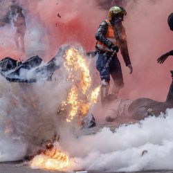 Un bote de gas lacrimógeno explota mientras los manifestantes intentan ayudar a los heridos frente al Parlamento de Kenia durante una huelga nacional para protestar contra los aumentos de impuestos y el Proyecto de Ley de Finanzas 2024 en el centro de Nairobi. | Foto:LUIS TATO/AFP