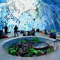 Un hombre visita la obra de arte interactiva 'Plastic Tsunami' de Mundano, parte del Congreso de Ciudades Residuo Cero, en Brasilia, Brasil. El Congreso reúne a expertos de varios países para discutir la buena gestión de residuos y reducir el impacto de la contaminación en el planeta. | Foto:EVARISTO SA / AFP