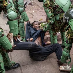 Un hombre reacciona en el suelo cuando agentes de la policía de Kenia lo arrestan mientras impiden que la gente se reúna para una manifestación planificada convocada después de una protesta mortal a nivel nacional contra un controvertido proyecto de ley de impuestos ahora retirado que dejó más de 20 muertos en el centro de Nairobi. | Foto:LUIS TATO/AFP