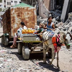 Un niño conduce un carro tirado por un burro que transporta a dos niños, bidones, sacos de harina y otros artículos mientras se evacuan del barrio de Tuffah, en el este de la ciudad de Gaza, en dirección a zonas del oeste, en medio del conflicto en curso en el territorio palestino entre Israel y Hamás. | Foto:OMAR AL-QATTAA / AFP