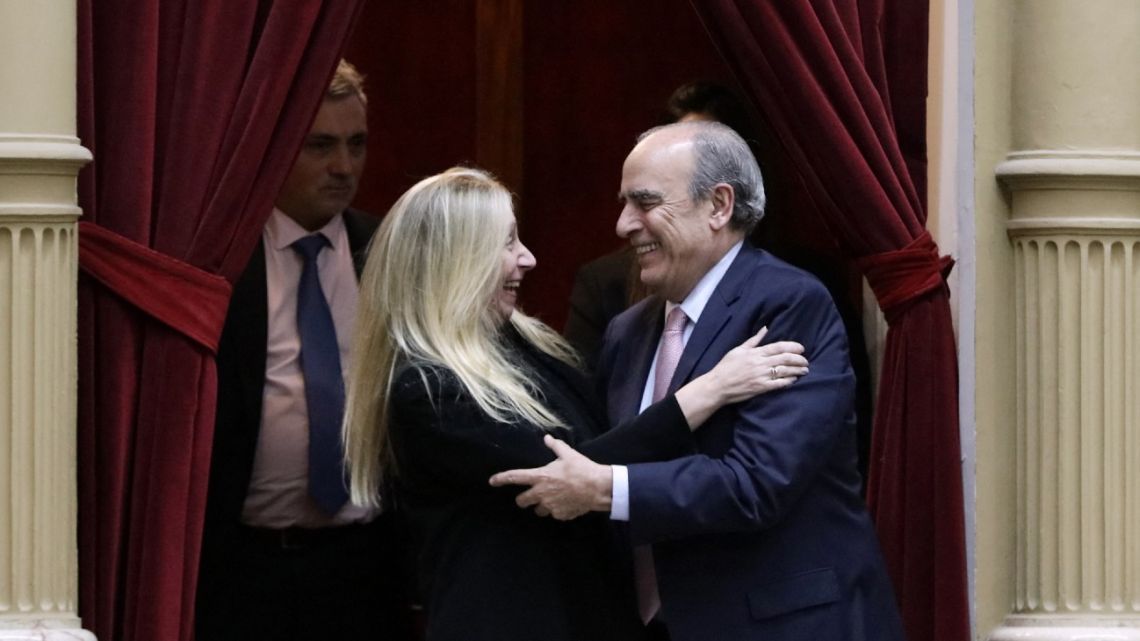 Presidential chief-of-staff Karina Milei, sister of President Javier Milei, and Cabinet Chief Guillermo Francos celebrate the approval of the 'Ley de Bases' law from a balcony in the Chamber of Deputies of the National Congress in Buenos Aires, early on June 28, 2024.