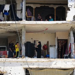 Las familias palestinas regresan a sus hogares gravemente dañados en un bloque de apartamentos afectado durante un bombardeo israelí, en la ciudad de Khan Yunis, en el sur de la Franja de Gaza, en medio del conflicto en curso entre Israel y el grupo militante palestino Hamas. | Foto:Eyad Baba / AFP