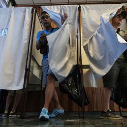 Los votantes salen de las cabinas después de marcar sus papeletas para votar en la primera ronda de las elecciones parlamentarias en un colegio electoral en La Possession, en la isla francesa de La Reunión, en el Océano Índico. Una Francia dividida está votando en elecciones parlamentarias de alto riesgo que podría ver al partido antiinmigrante y euroescéptico de Marine Le Pen llegar al poder en una primicia histórica. | Foto:Richard Bouhet / AFP