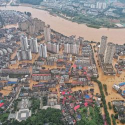 Esta fotografía muestra una vista aérea de edificios y calles inundados después de fuertes lluvias en Yueyang, en la provincia de Hunan, en el centro de China. | Foto:CNS / AFP