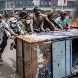 Los manifestantes corean consignas mientras utilizan mobiliario urbano como barricada para enfrentarse a los agentes de la policía de Kenia durante una manifestación antigubernamental convocada tras protestas mortales en todo el país por los aumentos de impuestos y un controvertido proyecto de ley de impuestos ahora retirado en el centro de Nairobi. | Foto:LUIS TATO/AFP