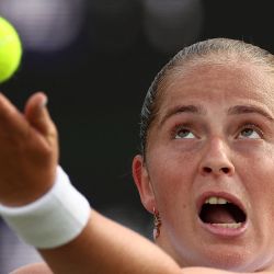 Jelena Ostapenko, de Letonia, lanza la pelota para servir contra Ajla Tomljanovic, de Australia, durante su partido de tenis femenino individual el segundo día del Campeonato de Wimbledon de 2024 en el All England Lawn Tennis and Croquet Club en Wimbledon, al suroeste de Londres. | Foto:HENRY NICHOLLS / AFP