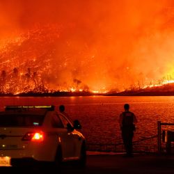 Los miembros de las fuerzas del orden observan cómo el incendio Thompson arde sobre el lago Oroville en Oroville, California. Una ola de calor está elevando las temperaturas, lo que ha provocado advertencias de incendio con bandera roja en todo el estado. | Foto:JOSH EDELSON / AFP