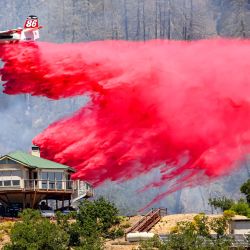 Un avión cisterna arroja retardante de fuego sobre una casa durante el incendio de Toll en Calistoga, California. Una ola de calor está elevando las temperaturas, lo que ha provocado advertencias de incendio con bandera roja en todo el estado. | Foto:JOSH EDELSON / AFP
