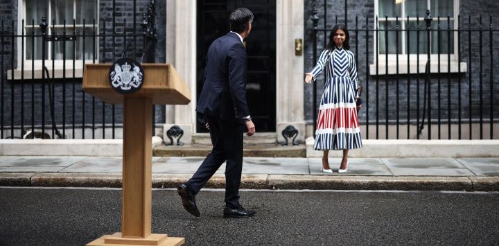 El Primer Ministro saliente de Gran Bretaña y líder del Partido Conservador, Risihi Sunak, camina hacia su esposa Akshata Murty, después de pronunciar una declaración tras su derrota en las elecciones generales, en las afueras del número 10 de Downing Street en Londres.