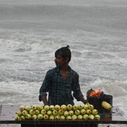 Un vendedor de maíz espera a los clientes durante las lluvias cerca del paseo marítimo en Mumbai. Intensas tormentas monzónicas azotaron la India, inundando partes de la capital financiera de Mumbai, mientras que un rayo en el estado oriental de Bihar mató al menos a 10 personas, dijeron funcionarios del gobierno. | Foto:PUNIT PARANJPE / AFP