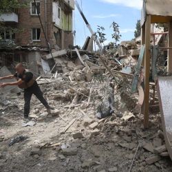 Un rescatista ucraniano limpia los escombros de un edificio residencial destruido tras un ataque con misiles en Kiev, en medio de la invasión rusa en Ucrania. El presidente de Ucrania, Volodymyr Zelensky, dijo que Ucrania estaba convocando una reunión de emergencia del Consejo de Seguridad de la ONU, luego de un aluvión mortal de ataques rusos en todo el país. | Foto:Anatolii Stepanov / AFP