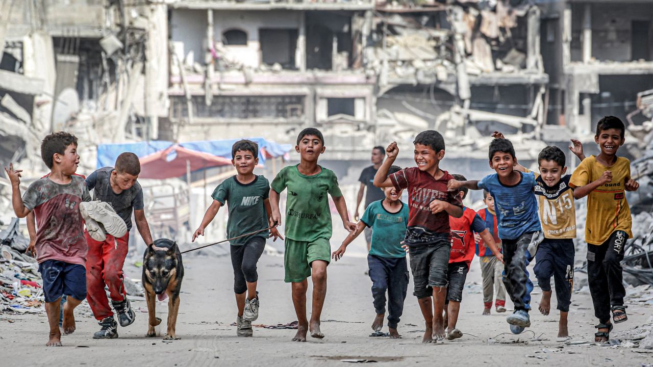 Niños caminan con un perro junto a edificios destruidos a lo largo de una calle en Khan Yunis, en el sur de la Franja de Gaza, en medio del conflicto en curso en el territorio palestino entre Israel y Hamás. | Foto:Bashar Taleb / AFP