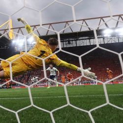 El delantero de Inglaterra Harry Kane anota el primer gol de su equipo desde el punto de penal superando al arquero holandés Bart Verbruggen durante el partido de fútbol semifinal de la UEFA Euro 2024 entre Holanda e Inglaterra en el BVB Stadion de Dortmund. | Foto:KENZO TRIBOUILLARD / AFP