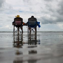 Una pareja se sienta en la playa antes de la llegada de la tormenta tropical Beryl a Corpus Christi, Texas. | Foto:Mark Félix / AFP