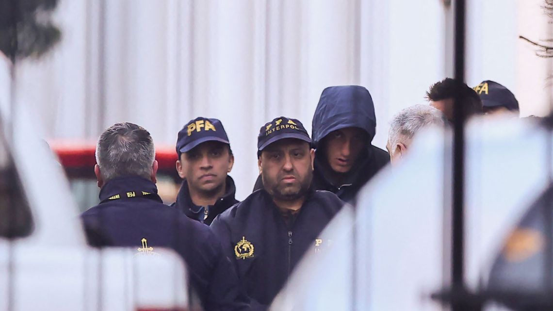 French national rugby player Oscar Jegou (right) is escorted by Argentina's Federal Police, as he leaves the Interpol headquarters in Buenos Aires for the city of Mendoza, prior to an experts' report in the case of rape, on July 11, 2024.