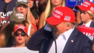 Trump se toma la oreja izquierda, al ser baleado en un acto de campaña en Pensilvania.
