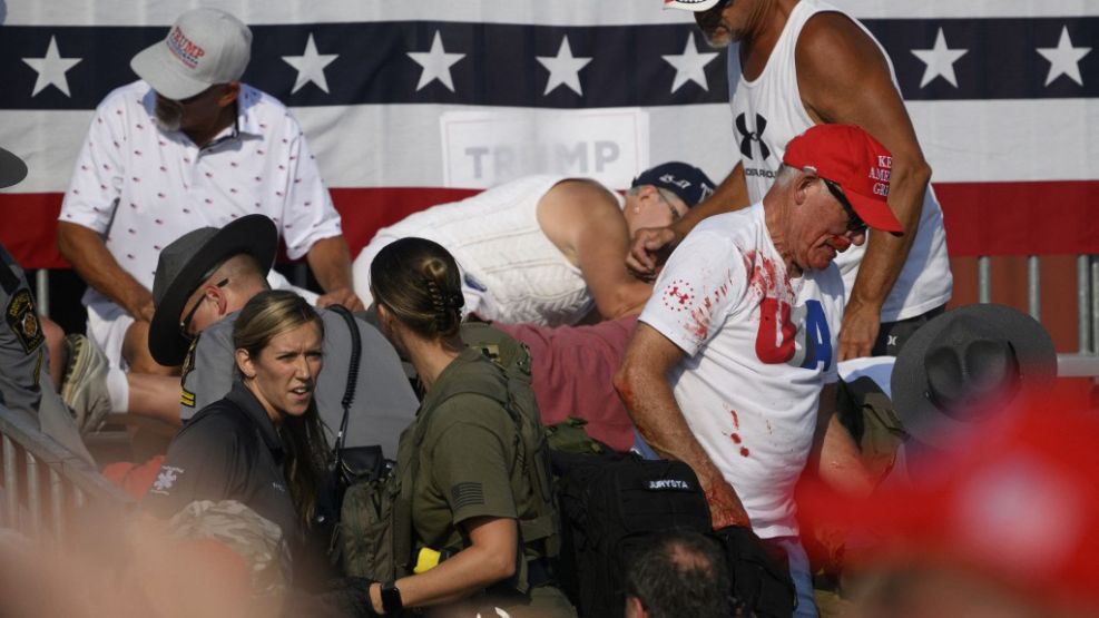 Un hombre baja las escaleras con manchas de sangre, del espectador baleado a su lado en el atentado a Trump.