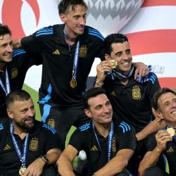 El entrenador de Argentina Lionel Scaloni celebra con su cuerpo técnico la victoria de su equipo en el partido de fútbol final del torneo Conmebol Copa América 2024 entre Argentina y Colombia en el Hard Rock Stadium, en Miami, Florida. | Foto:JUAN MABROMATA / AFP