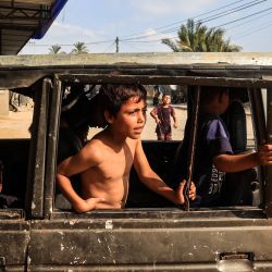 Niños desplazados internos juegan en un vehículo quemado en la ciudad de Deir al-Balah, en el centro de la Franja de Gaza, en medio del conflicto en curso entre Israel y el grupo militante palestino Hamas. | Foto:Eyad Baba / AFP