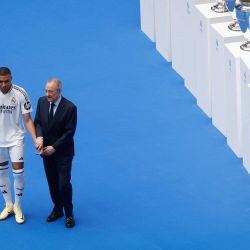 El delantero francés Kylian Mbappé posa con el presidente del Real Madrid, Florentino Pérez, durante su primera aparición como jugador del Real Madrid en el estadio Santiago Bernabéu de Madrid, tras firmar su nuevo contrato de cinco temporadas. | Foto:OSCAR DEL POZO / AFP