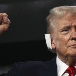 El expresidente estadounidense y candidato presidencial republicano de 2024, Donald Trump, con una venda en la oreja después de haber sido herido en un intento de asesinato, levanta el puño al llegar durante el primer día de la Convención Nacional Republicana de 2024 en el Foro Fiserv en Milwaukee, Wisconsin. | Foto:BRENDAN SMIALOWSKI / AFP