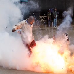 Un bote de gas lacrimógeno detona cuando un manifestante intenta patearlo en dirección a la policía durante las protestas antigubernamentales en Nairobi, Kenia. | Foto:TONY KARUMBA / AFP