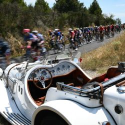El grupo de ciclistas pasa cerca de un coche convertible clásico Licorne durante la 16ª etapa de la 111ª edición de la carrera ciclista Tour de Francia, 188,6 km entre Gruissan y Nimes, en el sur de Francia. | Foto:MARCO BERTORELLO / AFP