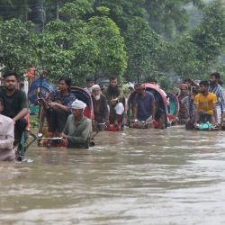 Imagen de personas viajando en bicitaxis por una calle inundada, en Dhaka, Bangladesh. | Foto:Xinhua