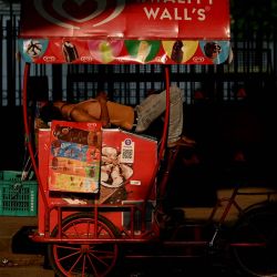 Un vendedor de helados descansa sobre su carrito en una calle de Nueva Delhi, India. | Foto:Sajjad Hussain / AFP