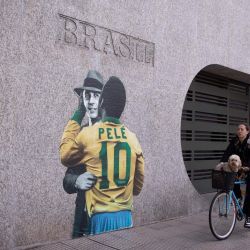 Una mujer conduce una bicicleta frente a la sede de la Embajada de Brasil, en la ciudad de Buenos Aires, capital de Argentina. | Foto:Xinhua/Martín Zabala