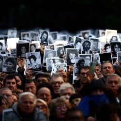 La gente tiene fotografías de las víctimas durante una ceremonia para conmemorar el aniversario del ataque con bomba de la Asociación Mutual Israelita de Argentina (AMIA) en Buenos Aires. 2024 marca el 30º aniversario del ataque con bomba de 1994 a la AMIA en Buenos Aires, que Dejó 85 muertos y más de 300 heridos. | Foto:Tomás Cuesta / AFP