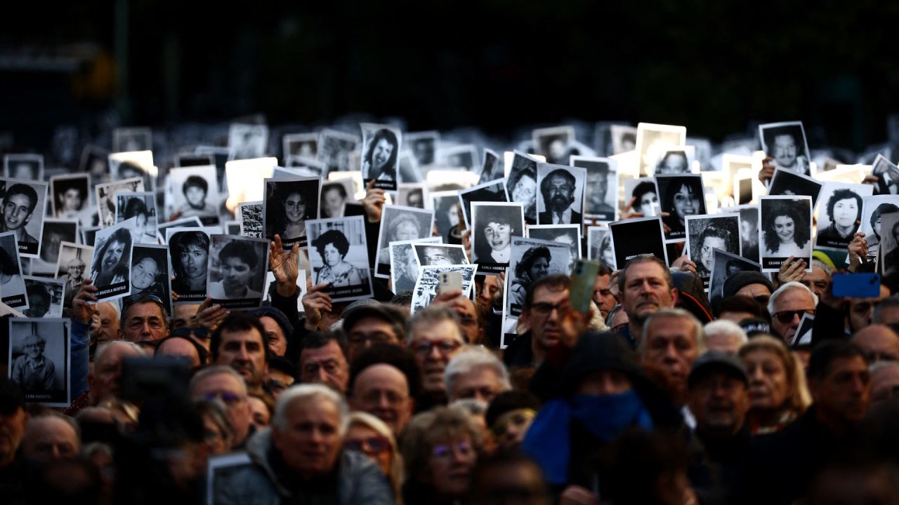 La gente tiene fotografías de las víctimas durante una ceremonia para conmemorar el aniversario del ataque con bomba de la Asociación Mutual Israelita de Argentina (AMIA) en Buenos Aires. 2024 marca el 30º aniversario del ataque con bomba de 1994 a la AMIA en Buenos Aires, que Dejó 85 muertos y más de 300 heridos. | Foto:Tomás Cuesta / AFP