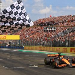 El piloto australiano de McLaren, Oscar Piastri, toma la bandera a cuadros del Gran Premio de Hungría de Fórmula Uno en el circuito de Hungaroring en Mogyorod, cerca de Budapest. | Foto:MARTIN DIVISEK / POOL / AFP