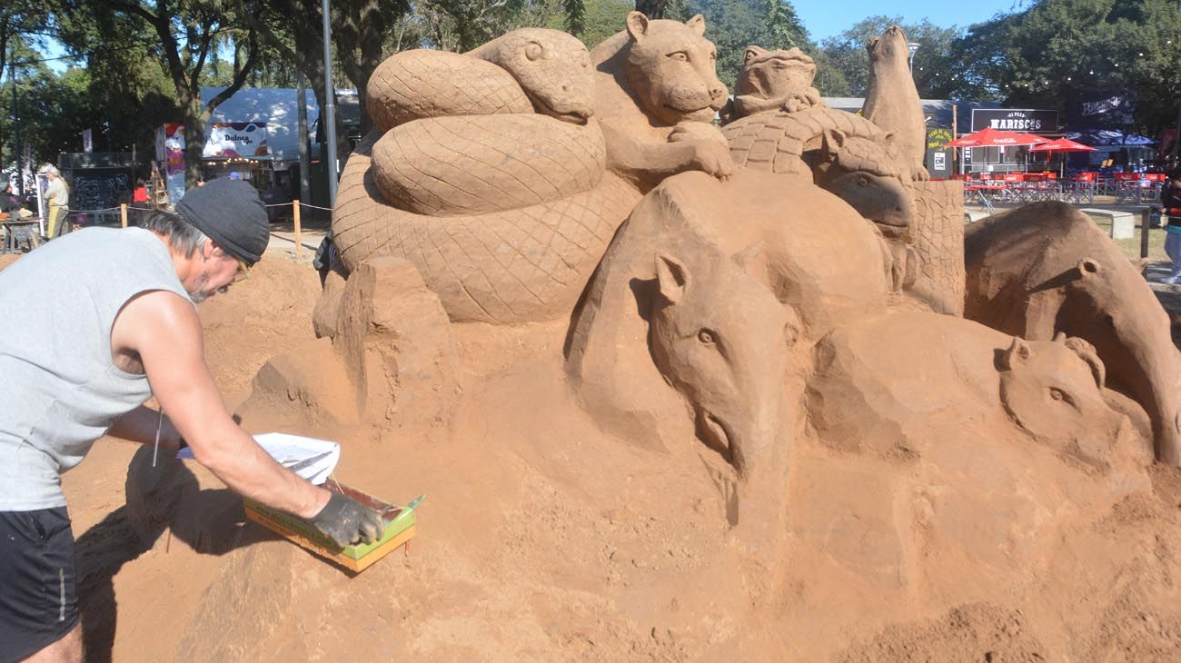 Alejandro Arce dando las puntadas finales a la monumental escultura en arena.