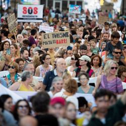 La gente participa en una manifestación para protestar contra el exceso de turismo y los precios de la vivienda en la isla de Mallorca, en Palma de Mallorca, España. | Foto:JAIME REINA / AFP