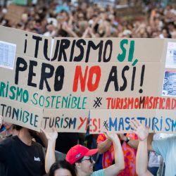 La gente sostiene un cartel que dice “Turismo sí, pero no así” durante una manifestación para protestar contra el exceso de turismo y los precios de la vivienda en la isla de Mallorca, en Palma de Mallorca, España. | Foto:JAIME REINA / AFP