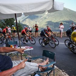 Un espectador aplaude al borde de la carretera mientras el ciclista esloveno del equipo UAE Team Emirates, Tadej Pogacar, vistiendo el maillot amarillo de líder general, pedalea en el ascenso del Col de la Colmiane durante la 20ª etapa de la 111ª edición de la carrera ciclista del Tour de Francia, 132,8 km entre Niza y Col de la Couillole, sureste de Francia. | Foto:ANNE-CHRISTINE POUJOULAT / AFP