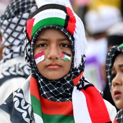 Los participantes que portan banderas palestinas observan durante un desfile que marca el año nuevo islámico en Banda Aceh, Indonesia. | Foto:CHAIDEER MAHYUDDIN / AFP