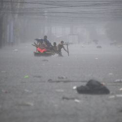 Los rescatistas reman en sus botes a lo largo de una calle inundada en Manila, Filipinas, en medio de las fuertes lluvias provocadas por el tifón Gaemi. | Foto:TED ALJIBE / AFP