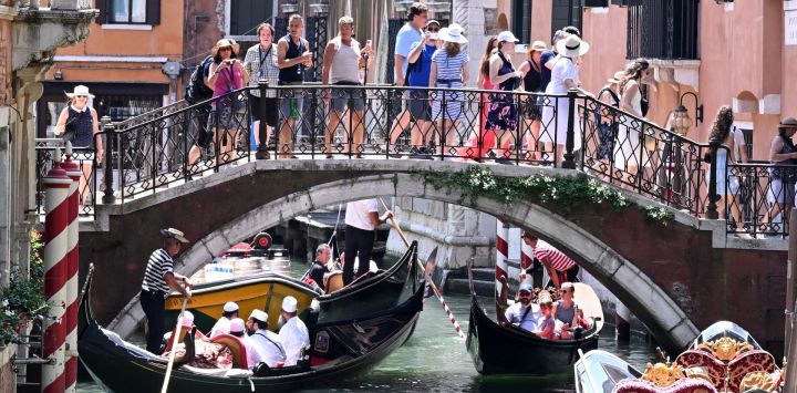 Imagen de turistas vistos paseando en góndolas, en Venecia, Italia.